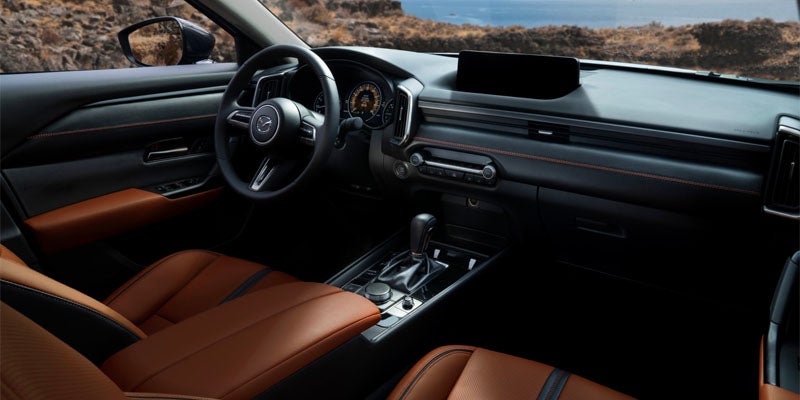 Premium Mazda CX-70 interior featuring brown leather seats, a multifunction steering wheel
