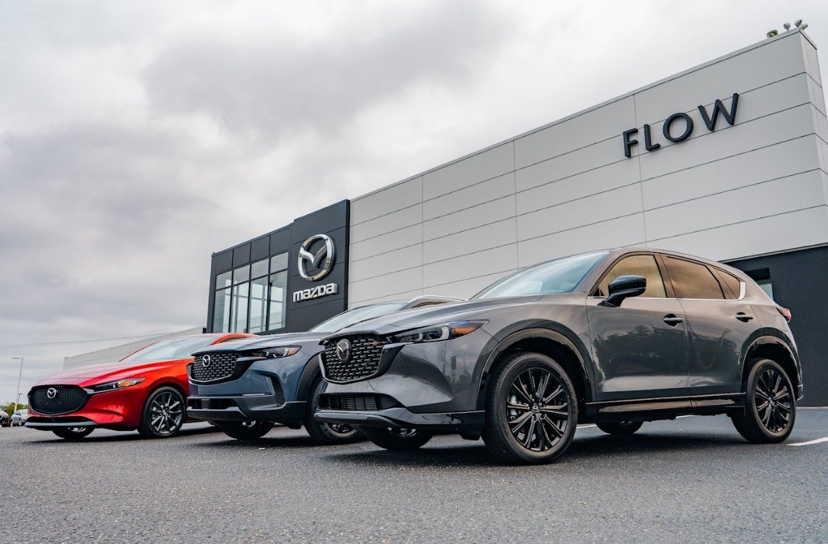 three Mazda vehicles in front of the Flow Mazda of Fayetteville dealership