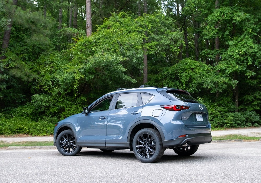 Blue 2025 Mazda CX-5 SUV for sale. The car is parked and the driver's side window is open
