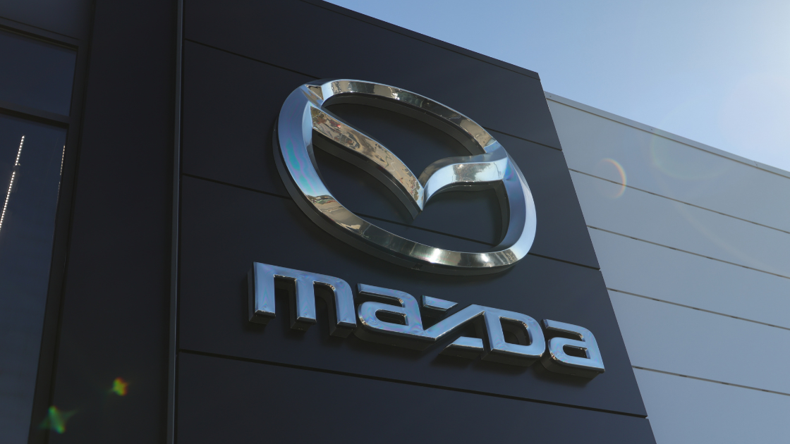 Close up photo of the Mazda logo on the outside of the Flow Mazda of Fayetteville dealership